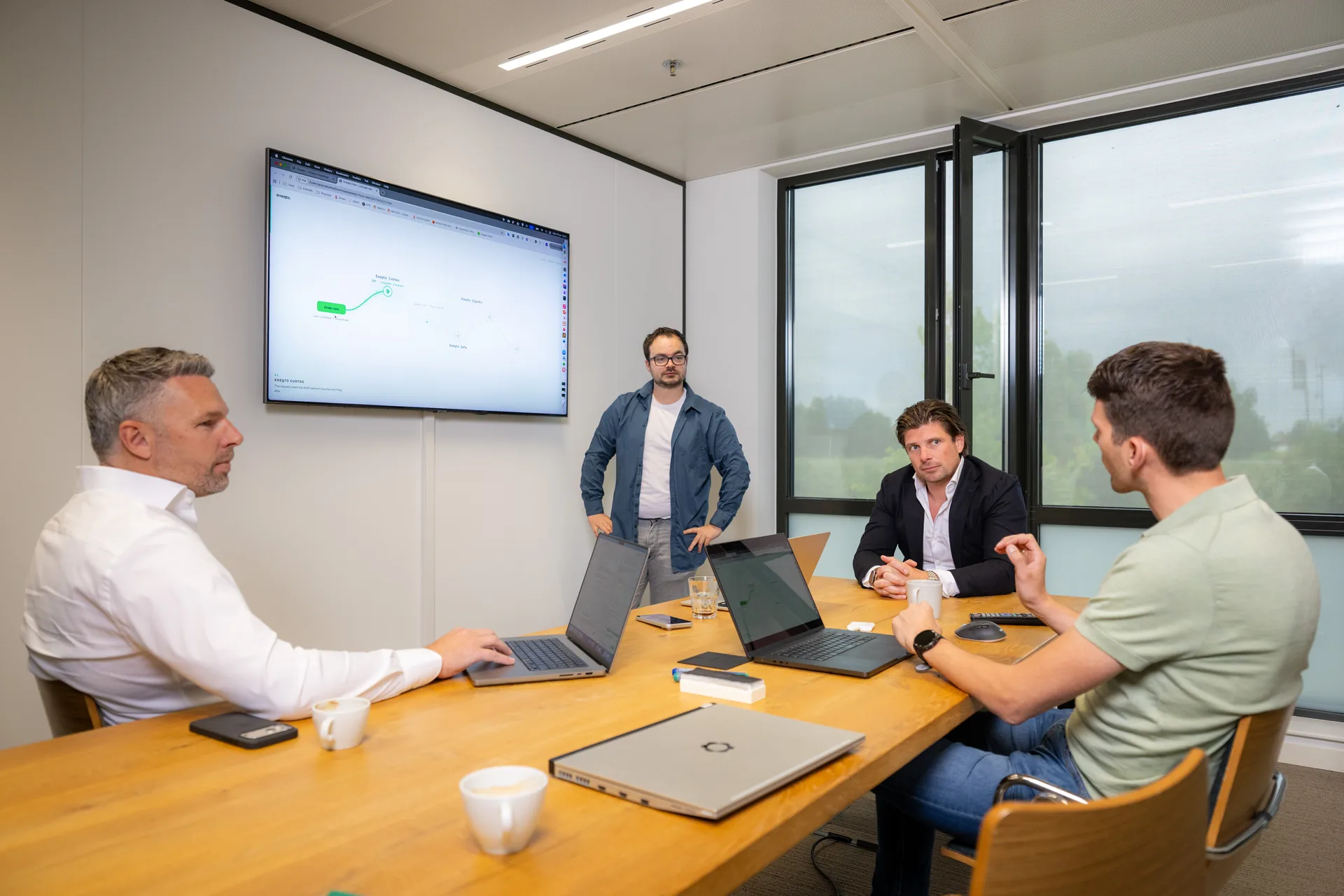 Emendis-team in overleg tijdens een sessie bij een tv-scherm met het Eneqto-platform in het kantoor in Veenendaal